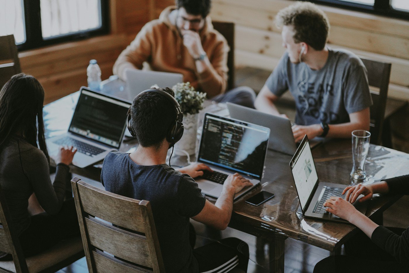 Professionals collaborating around computers in a shared workspace